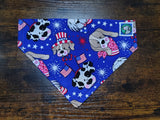 Dog bandanna with patriotic and cartoon-themed designs on a wooden surface