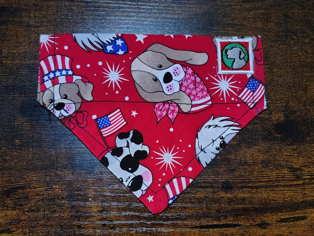Red dog bandanna with dog-themed designs on a wooden surface