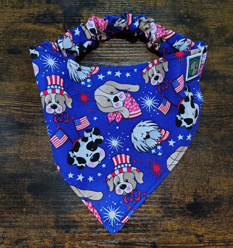 Blue bandana with dog-themed designs on a wooden surface
